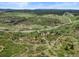 Scenic aerial view featuring a vast landscape with rolling hills and scattered greenery under a blue sky at 8821 S Perry Park Rd, Larkspur, CO 80118