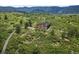 Stylish modern home with natural wood siding and expansive windows, perfectly situated in a green, natural landscape at 8821 S Perry Park Rd, Larkspur, CO 80118