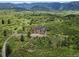 Stunning modern home with wood and glass design, set amongst lush greenery, offering panoramic mountain views at 8821 S Perry Park Rd, Larkspur, CO 80118