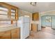 Cozy kitchen featuring wood cabinets, laminate countertops, and a classic white refrigerator at 8821 S Perry Park Rd, Larkspur, CO 80118