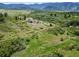 Picturesque landscape with green fields, scattered trees, and a unique rock formation, creating a serene environment at 8821 S Perry Park Rd, Larkspur, CO 80118