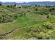 Expansive green meadow with scattered trees and rock formations, offering a peaceful natural retreat at 8821 S Perry Park Rd, Larkspur, CO 80118