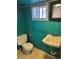 Turquoise bathroom with toilet, sink, mirror and a window at 2134 S Corona St, Denver, CO 80210