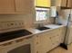 Quaint kitchen with a stained glass window above the sink and classic white cabinetry at 2134 S Corona St, Denver, CO 80210