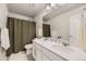 Bathroom featuring double vanity, shower with curtain, and white towel at 12749 Horton Ct, Parker, CO 80134