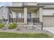 Covered front porch with stone accents, black metal railings, and manicured landscaping at 12749 Horton Ct, Parker, CO 80134