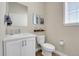 Well-lit half bathroom with a modern vanity, toilet, and stylish fixtures, perfect for guests at 6650 Zuni St, Denver, CO 80221