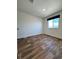 The bedroom features wood-look flooring, a black window shade, and white walls, offering a blank canvas at 5060 N Walden Way, Denver, CO 80249