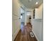 Hallway view featuring a bathroom, bedroom, and built-in shelves with wood-look floors at 5060 N Walden Way, Denver, CO 80249
