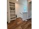 Hallway with beautiful wood-look floors and built-in shelving for storage and decor display at 5060 N Walden Way, Denver, CO 80249