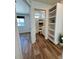 Hallway view featuring a bathroom, bedroom, and built-in shelves with wood-look floors at 5060 N Walden Way, Denver, CO 80249