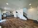 Open concept living room with hardwood floors, staircase, and a view of the modern kitchen at 5060 N Walden Way, Denver, CO 80249