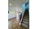 The well-lit living room features wood flooring and leads to a staircase, blending comfort with modern design at 5060 N Walden Way, Denver, CO 80249