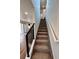 Carpeted staircase with modern black railings and white walls connecting the levels of a brightly lit home at 5060 N Walden Way, Denver, CO 80249
