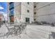 Outdoor patio with iron table and chairs, with building featuring large glass windows and balconies at 1777 Larimer St # 2201, Denver, CO 80202