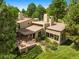 An aerial view of a stucco home with a pergola patio, lush landscaping, and a serene setting at 2107 Ridge Plaza Dr, Castle Rock, CO 80108