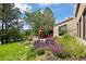Picturesque backyard with a pergola, stone wall, and vibrant purple flowers in a lush green setting at 2107 Ridge Plaza Dr, Castle Rock, CO 80108