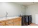 Laundry room with wooden cabinets, countertop, sink, and stainless steel washer and dryer at 2107 Ridge Plaza Dr, Castle Rock, CO 80108