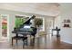 Elegant living room featuring a grand piano, hardwood floors, and bright natural light at 2107 Ridge Plaza Dr, Castle Rock, CO 80108