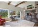 Bright living room featuring a stone fireplace, plush sofa, and natural lighting at 2107 Ridge Plaza Dr, Castle Rock, CO 80108
