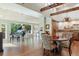 Open living area with hardwood floors, beamed ceilings, piano, and kitchen in background at 2107 Ridge Plaza Dr, Castle Rock, CO 80108
