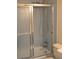 Bathroom with a shower/bathtub combo featuring light blue tiling, shower head, sliding shower door, toilet at 1300 Spruce St, Denver, CO 80220