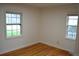 An empty bedroom is light and airy with beautiful hardwood floors and two double hung windows at 1300 Spruce St, Denver, CO 80220