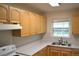Bright kitchen with light wood cabinets, white countertops, and a stainless steel sink under a window at 1300 Spruce St, Denver, CO 80220
