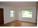 Bright living room with gleaming hardwood floors, white walls, and large windows offering natural light at 1300 Spruce St, Denver, CO 80220