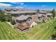 Backyard aerial view featuring wood deck, lush lawn, and mature landscaping at 22002 E Irish Dr, Aurora, CO 80016