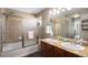 Spacious bathroom featuring a shower-tub combo with tile surround and a double sink vanity with a granite countertop at 22002 E Irish Dr, Aurora, CO 80016
