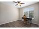 Bright bedroom featuring a ceiling fan and dark wood-look floors, filled with natural light from the large window at 22002 E Irish Dr, Aurora, CO 80016