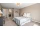 Comfortable bedroom adjacent to the bathroom, featuring a plush bed, neutral tones and soft carpeting at 22002 E Irish Dr, Aurora, CO 80016