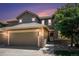 Charming two-story home featuring a two car garage, stone accents and landscaped yard at dusk at 22002 E Irish Dr, Aurora, CO 80016