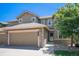 Inviting two-story home with a two car garage, stone accents, manicured lawn, and mature shade tree at 22002 E Irish Dr, Aurora, CO 80016