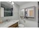 Cozy bathroom featuring a stone countertop vanity, toilet, and mirrored storage at 45321 Summit Rd, Parker, CO 80138