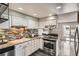 Bright kitchen features granite counters, mosaic backsplash, and stainless-steel appliances at 2974 S Parker Ct, Aurora, CO 80014