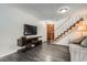 Open living room features a staircase, vinyl floors, and a mounted television at 2974 S Parker Ct, Aurora, CO 80014