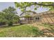 Expansive backyard view showcasing the covered patio, lush lawn, and mature trees at 16602 E Gunnison Pl, Aurora, CO 80017