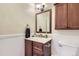 Classic powder room with dark wood vanity, framed mirror, and beadboard paneling at 16602 E Gunnison Pl, Aurora, CO 80017
