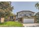 Charming two-story home with a brick and gray exterior, lush green lawn, and a basketball hoop above the garage at 16602 E Gunnison Pl, Aurora, CO 80017