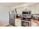 Close-up of the kitchen area showcasing stainless steel appliances, wooden countertops, and stylish decor at 16602 E Gunnison Pl, Aurora, CO 80017
