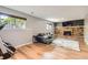 Cozy living room features a brick fireplace, multiple windows, and wood laminate flooring at 16602 E Gunnison Pl, Aurora, CO 80017