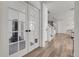 Bright entryway with wood floors, white walls, and glass french doors to the home gym at 4358 S Nepal Ct, Centennial, CO 80015