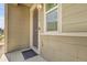 Close-up of the front door of a house with beige siding and a welcome mat on the porch at 4358 S Nepal Ct, Centennial, CO 80015