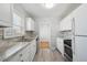 A bright kitchen features white cabinets, marble countertops, and stainless steel appliances at 1934 Macon St, Aurora, CO 80010