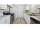 Well-lit kitchen with stainless steel appliances, white cabinets, marble countertops, and modern backsplash at 1934 Macon St, Aurora, CO 80010