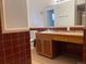 Clean bathroom featuring a vanity with wood cabinets and brown tile at 2696 S Jersey St, Denver, CO 80222