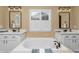 A luxurious bathroom featuring a soaking tub, double vanity, and white countertops at 30 Stewart Way, Erie, CO 80516