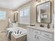 Bathroom featuring a soaking tub, double sinks, and stone countertops creating a relaxing space at 30 Stewart Way, Erie, CO 80516